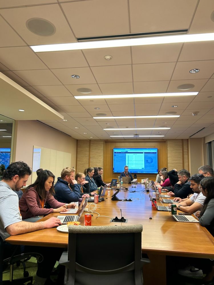 Salesforce professionals sitting in Boston Salesforce office with laptops.