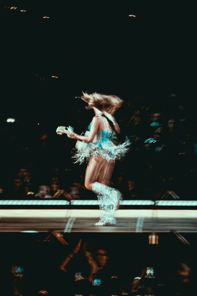 Blurry photo of Taylor Swift on stage at the eras tour during the fearless era 
