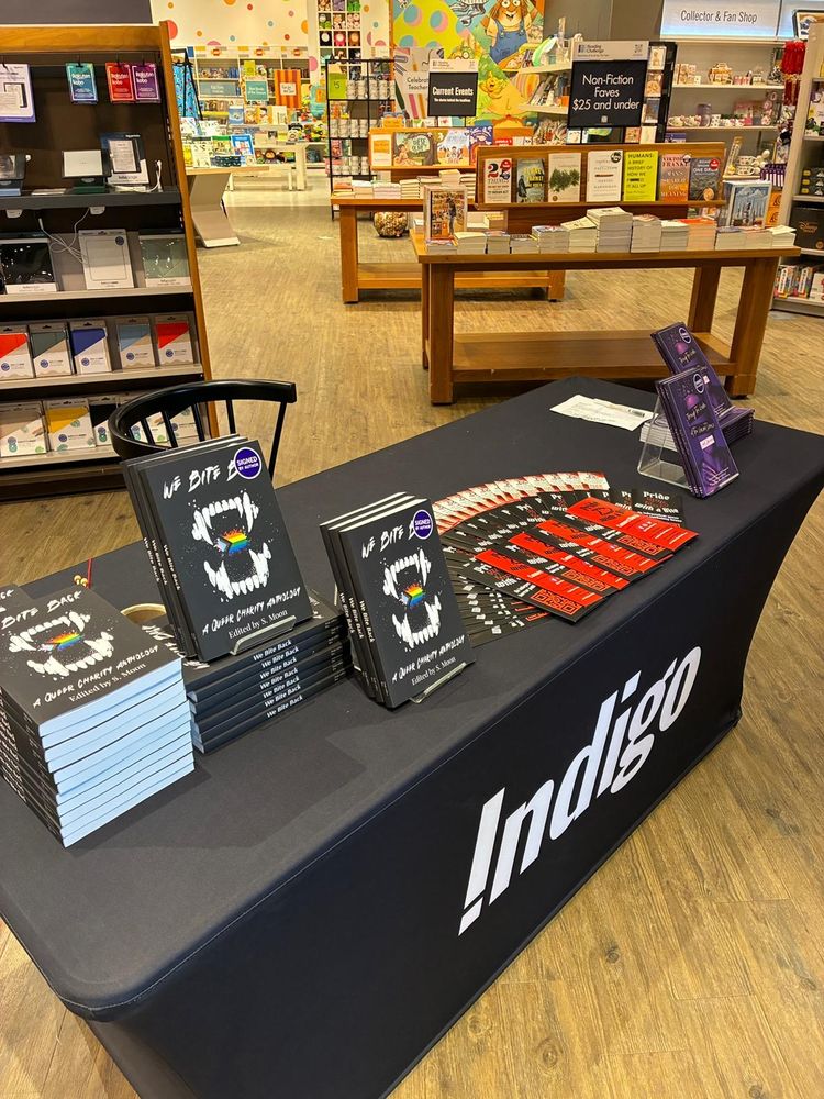 A display of a signing table with copies of "We Bite Back" and "Through the Realm of the Vacant Prince."