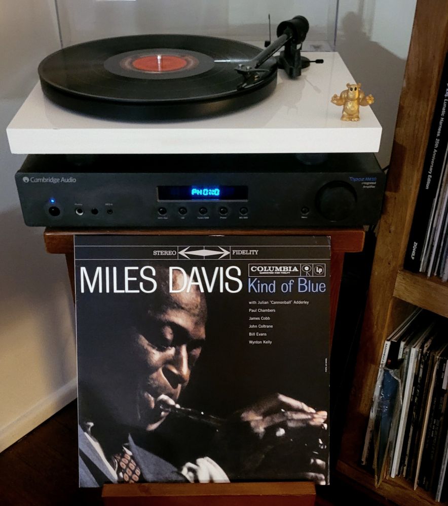 Vinyl record on turntable, cover displayed. 
Artist: Miles Davis
Album: Kind of Blue 
