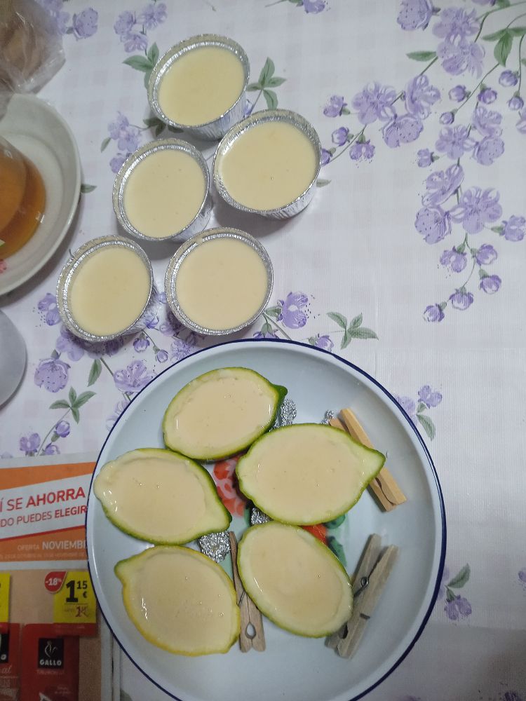 Limones partidos por la mitad con jugo de limón por dentro, llevan (jugo de limón, nata para montar y azúcar). 
A su lado hay cuenquitos de aluminio para magdalenas 