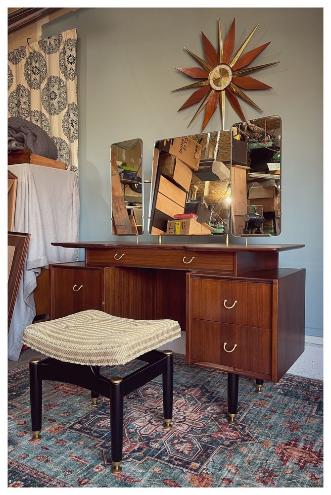 Mid century modern dressing table with mirrors and stool. Black lacquered legs with brass feet. Tola veneers and brass handles on drawers that sit either side of the kneehole. One central drawer underneath the ‘floating’ top.