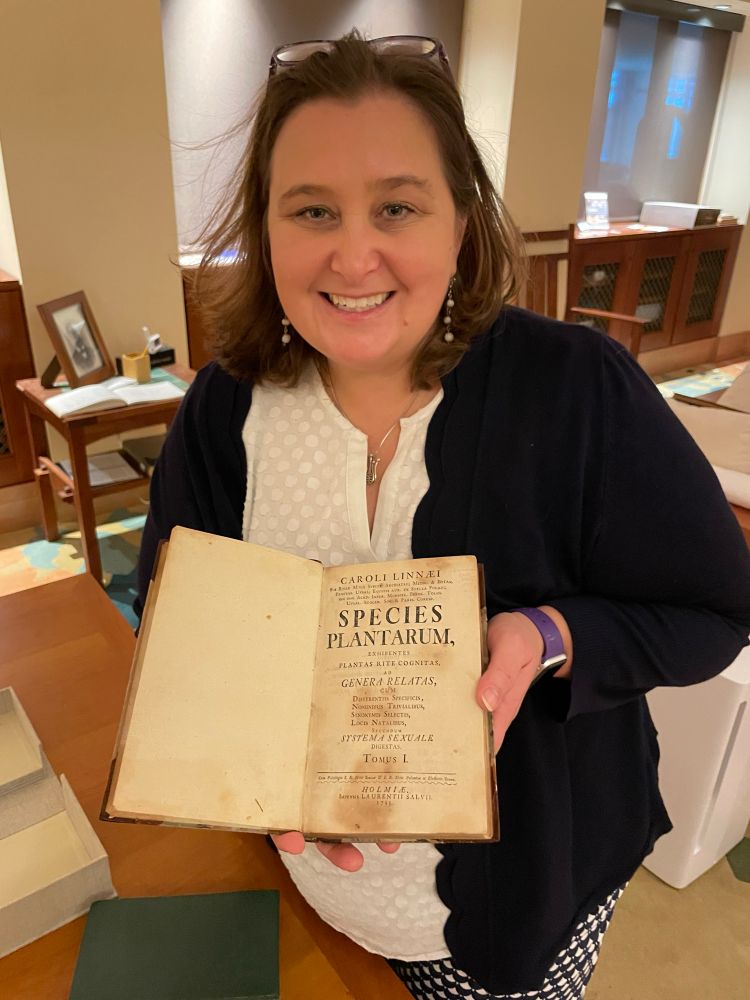 Me holding a book open to the front page of Species Plantarum.
