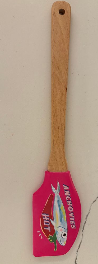 a spatula with an anchovy holding a hot pepper that says ANCHOVIES HOT