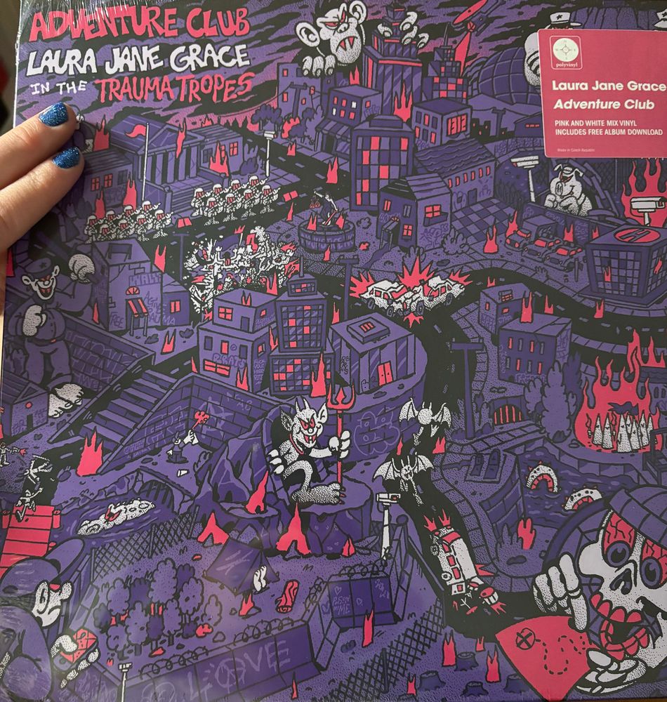 adventure club record by laura jane grace in the trauma tropes. the cover shows a hellish urban environment depicted in purples and reds. there’s scattered graffiti and fires and skulls and i’m doing my best but it’s gonna be tough to do this one justice in alt text!