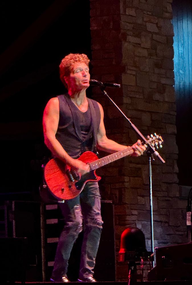 Photo of Richard Marx playing guitar and singing live. His hair looks great!