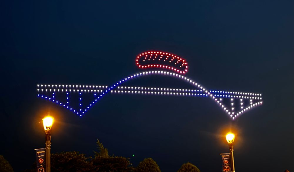 A drone show where the drones have formed Milwaukee’s Hoan Bridge with a drone sausage floating above it. 