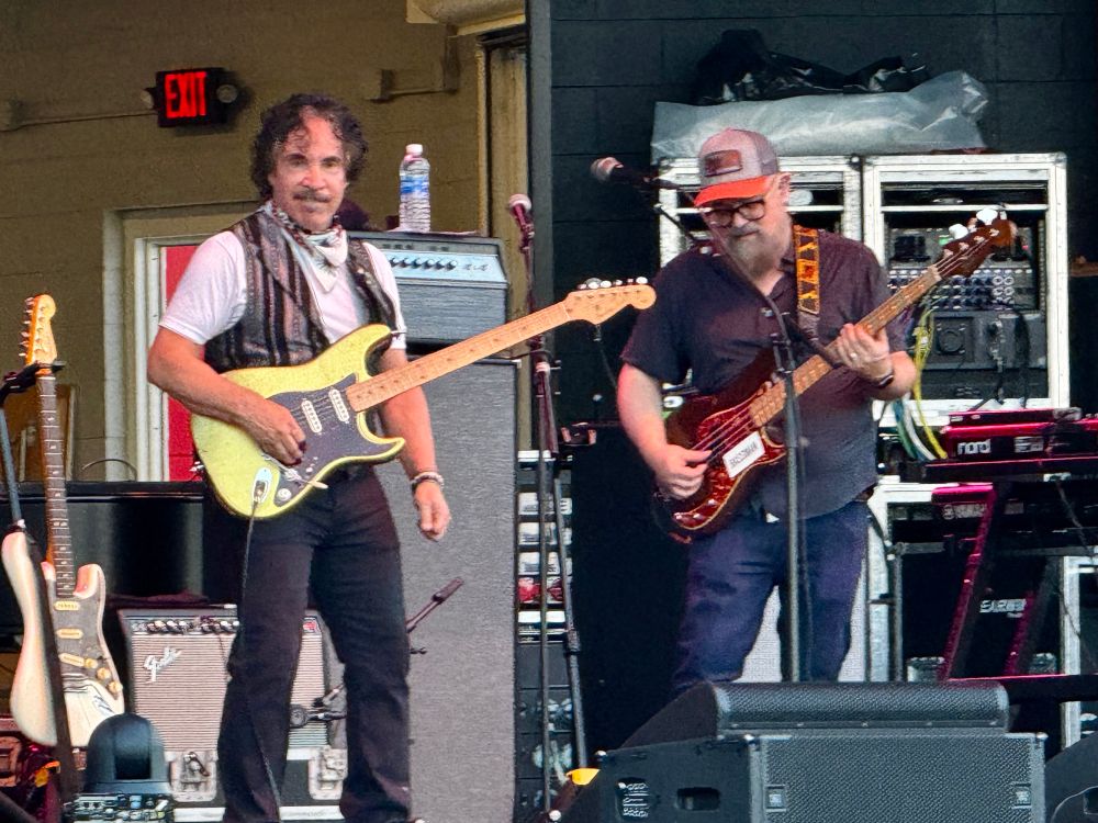 Photo of two men with guitars. John Oates is on the left. 