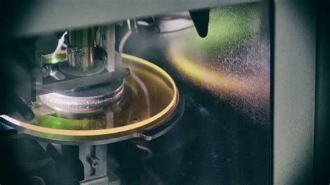 Yellow DVD sized zinc selenide disc illuminated by LED lights inside instrument vacuum chamber 