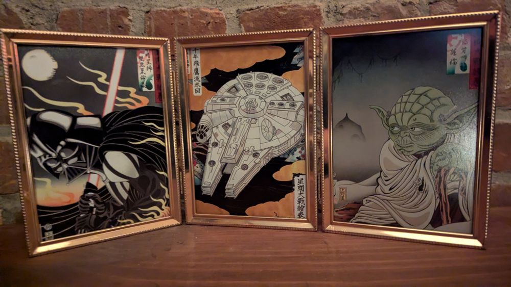 Images of Darth Vader, the Millennium Falcon, and Yoda in a Japanese wood print style