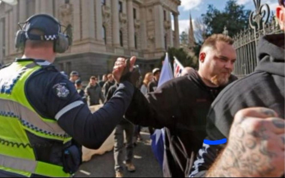 Vic cop high fiving a passing fascist meathead