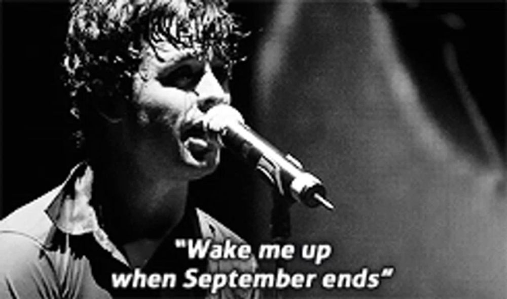 a man singing into a microphone with the words " wake me up when september ends " on the bottom