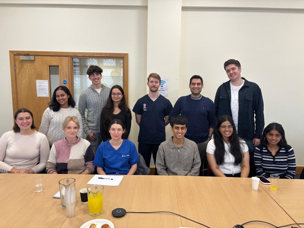 a group of medical students smiling at the camera at a conference table