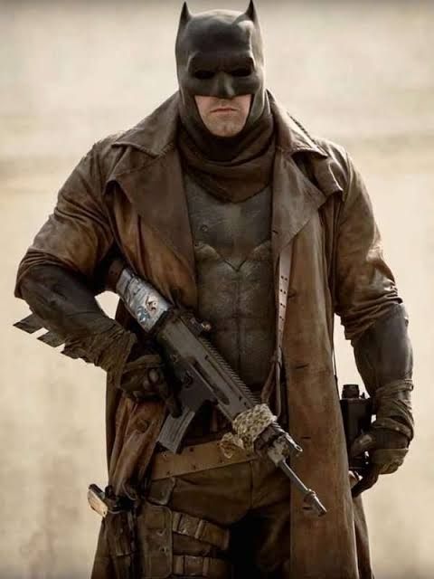 Batman usando um traje meio militar e usando arma de fogo.