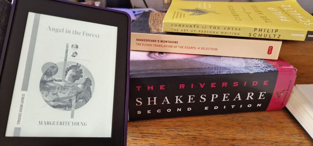 4 books. Angel in the Forest by Marguerite Young on a kindle, Comforts of The Abyss by Philip Schultz (yellow), Shakespeare's Montaigne, The Florio Translation of the Essays: A Selection, The Riverside Shakespeare, Second Edition.