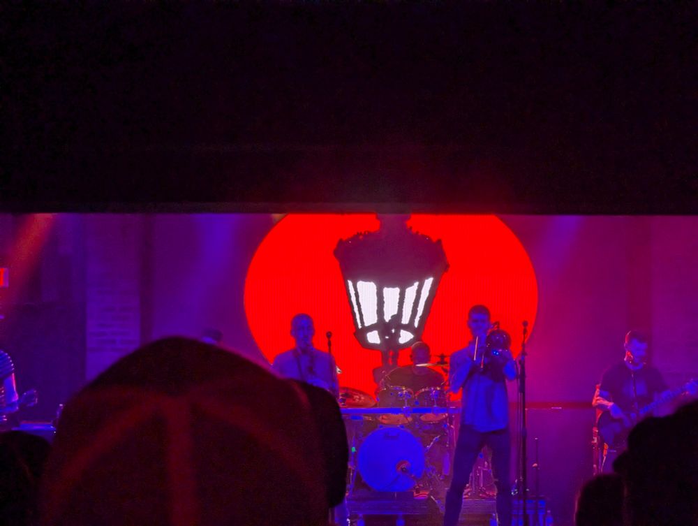 the band Streetlight Manifesto plays on stage in front of their logo, a streetlight 