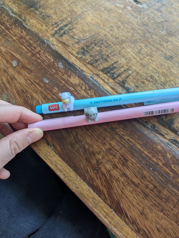 Stylo bleu et rose avec figurine de lama et de chat