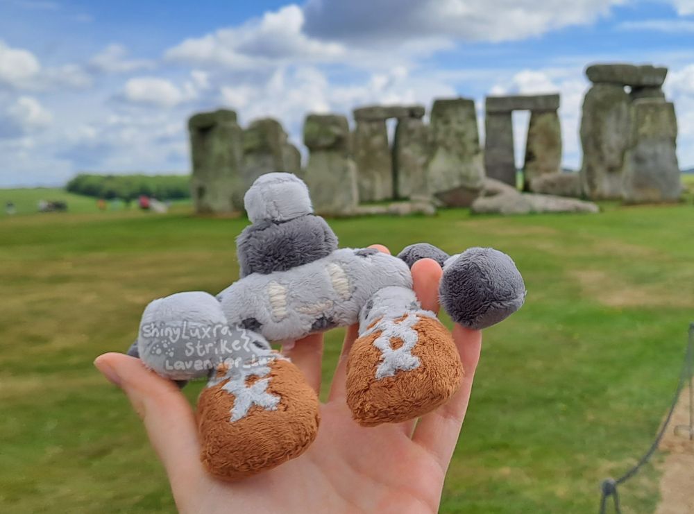 A little Stonjourner plush I made held up in front of the actual Stonehenge