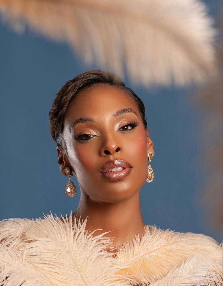 Miss France 2025 entourée de plumes beiges 