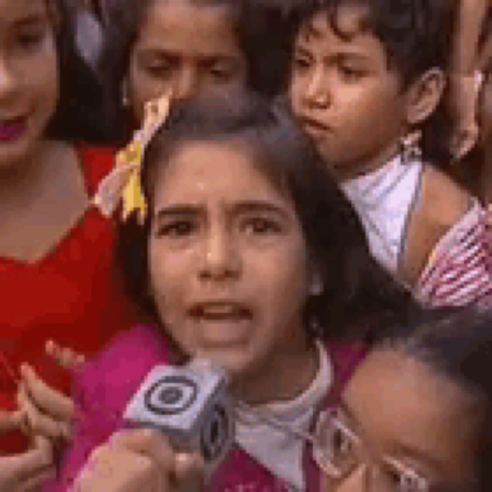 a girl is holding a microphone in front of a group of children .