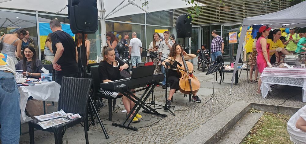 live piano and cello performance, food stalls, and people socializing.