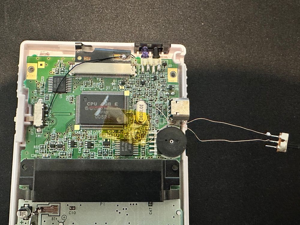 The inside of a Game Boy Color with a switch wired to TEST1