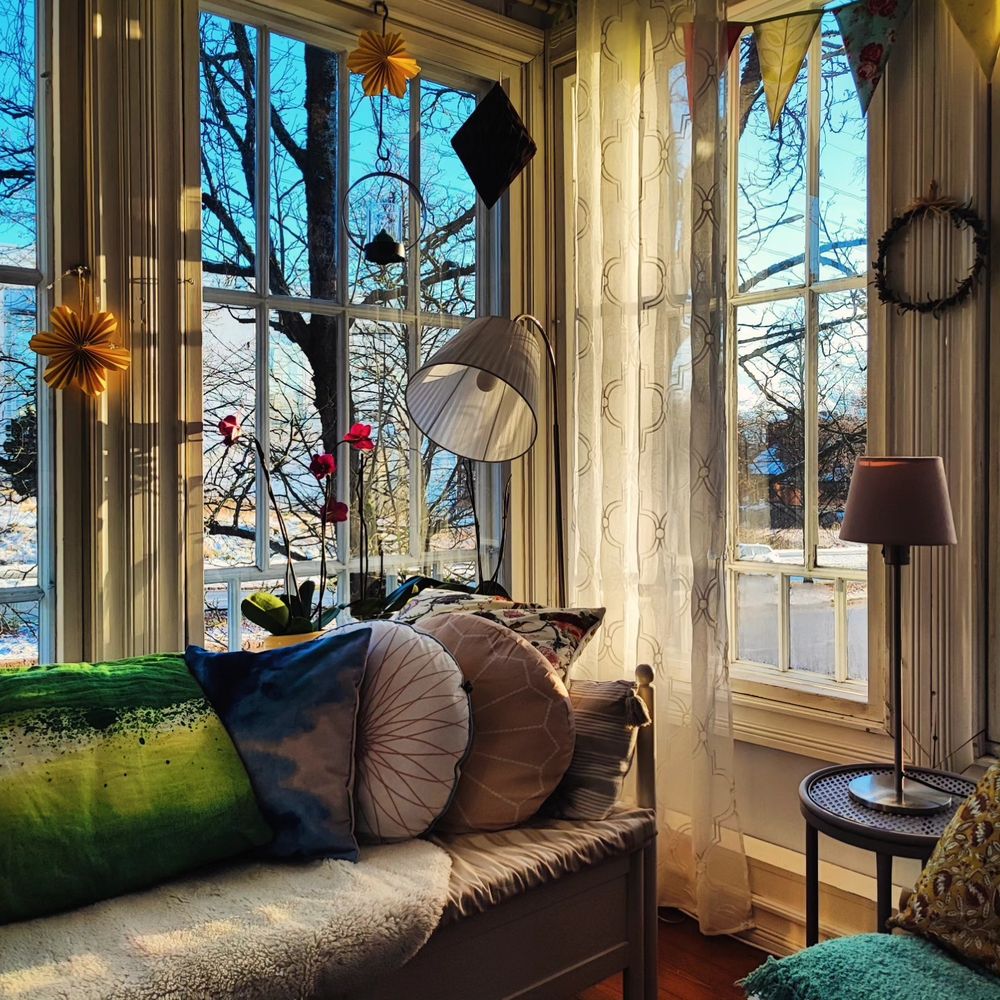 Verandan ikkunat, tyynyjä, lamppuja ja muuta tilpehööriä.