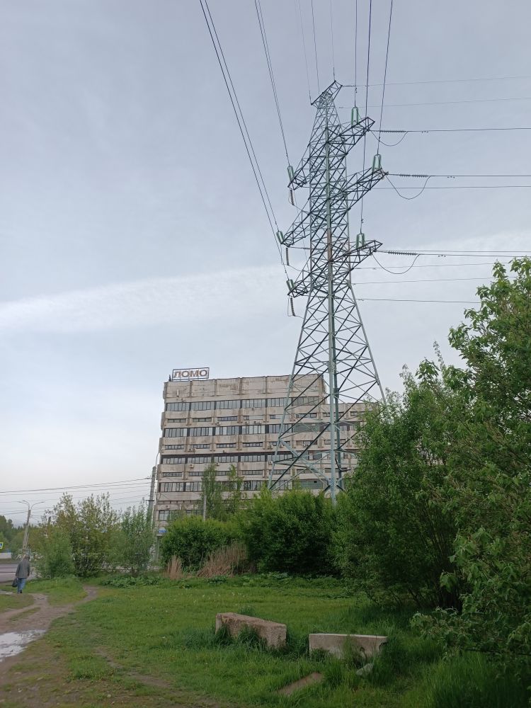 Серое высокое индустриальное здание советских лет, вывеска ЛОМО сверху.