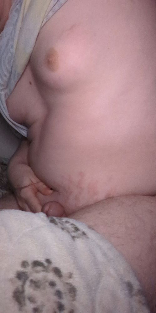 Kirby hunched over in bed lifting her shirt