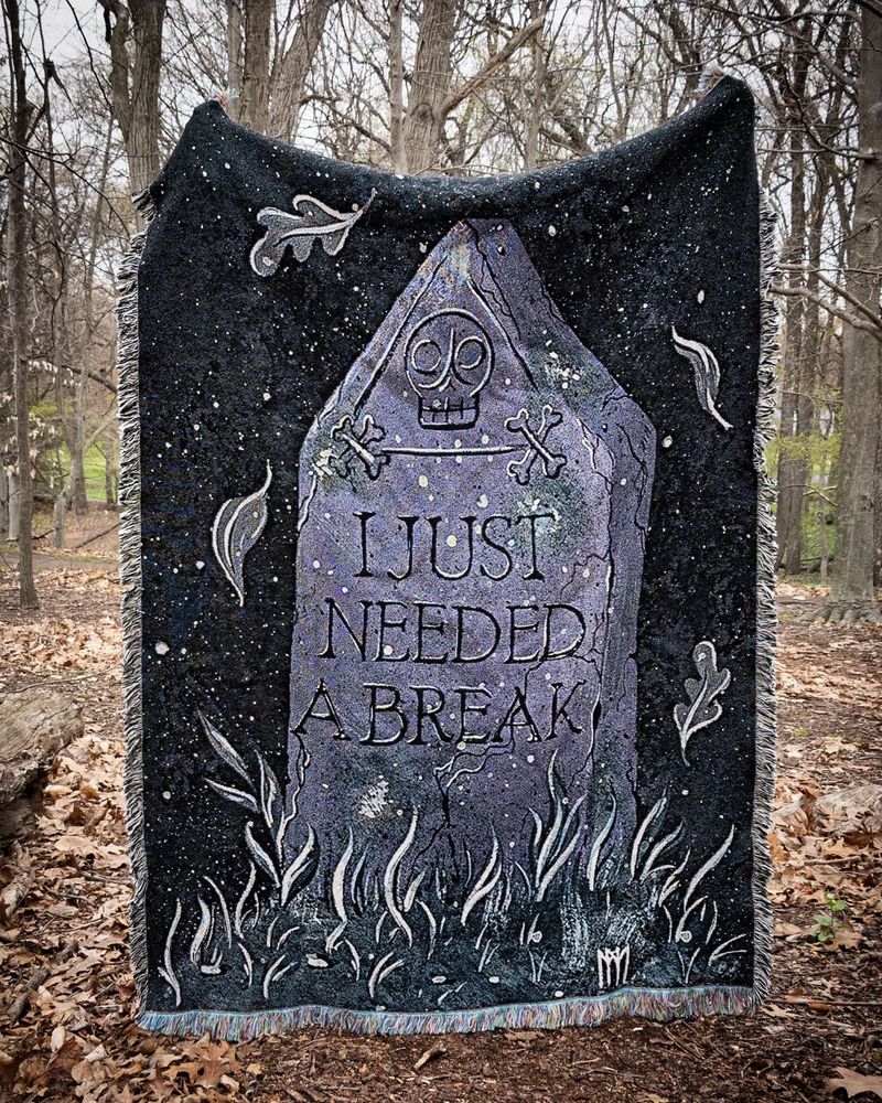 A blanket with an image of a tombstone reading "I Just Needed A Break"