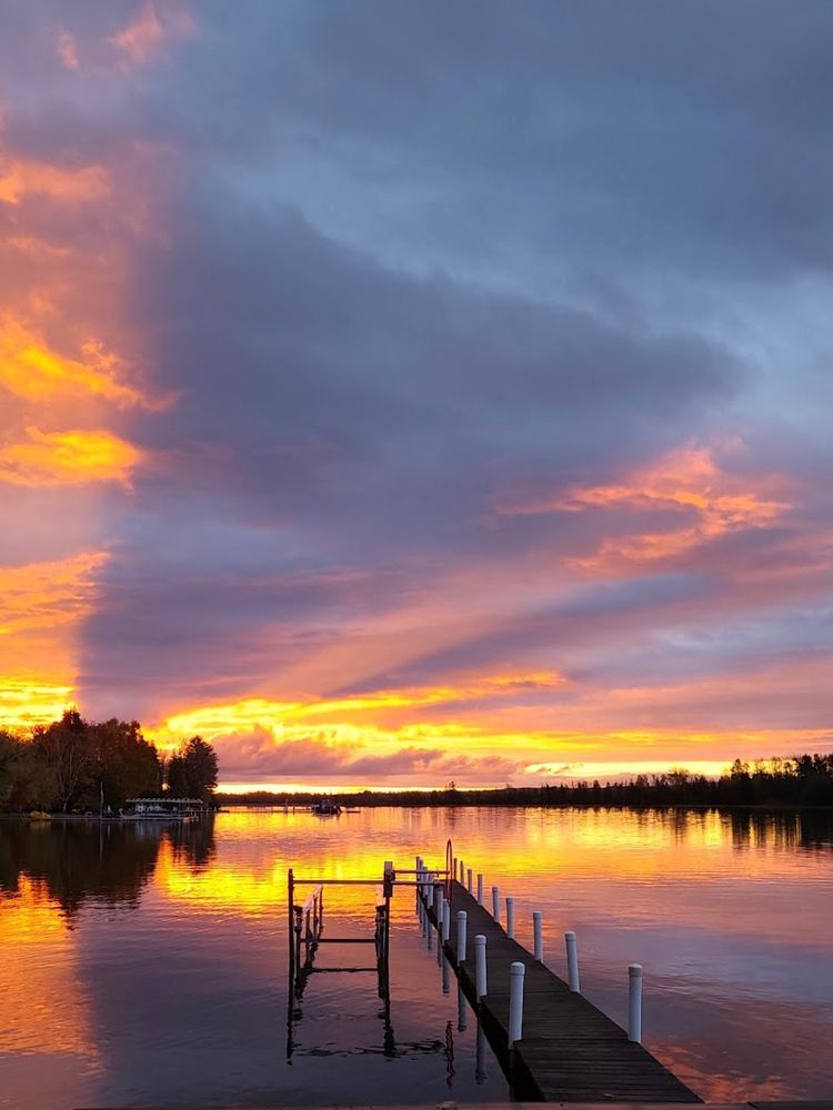 a trix yogurt sunset over calm water. there's an empty dock. it's peaceful.