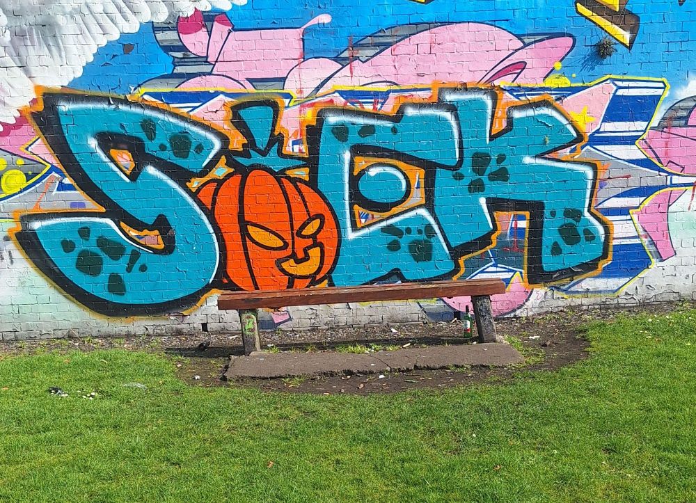 Bench with graffiti behind