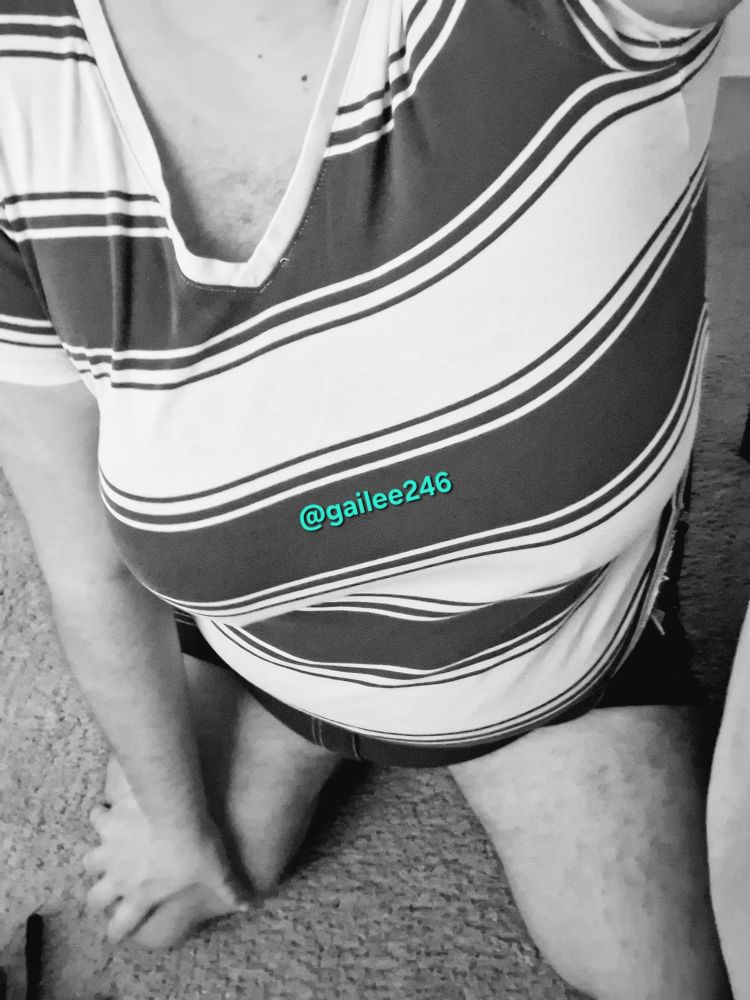 Black and white selfie of me kneeling, wearing a striped v-neck tee and shorts.