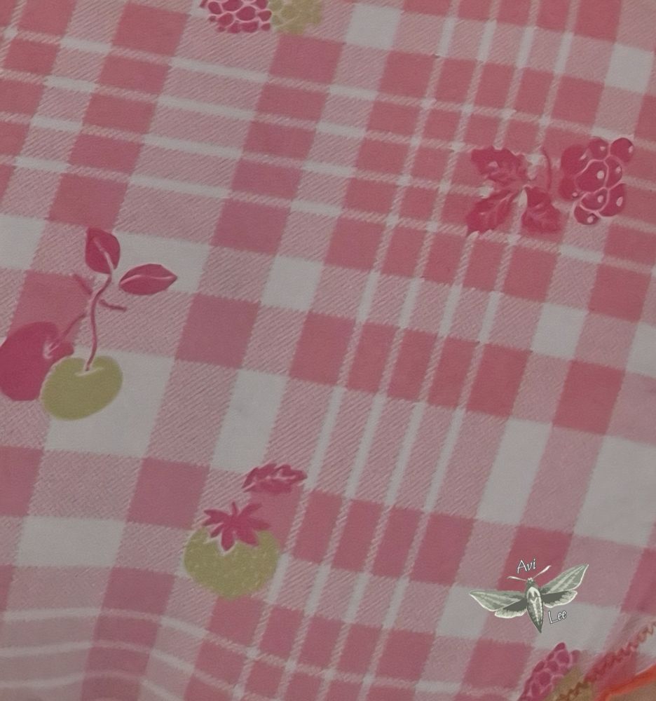 Fabrick with an orange ans white gingham pattern and some orange and olive green fruits printed on it (cherries, different kinds of berries). My watermark, a moth with the text "Avi Lee" around it, is in the corner