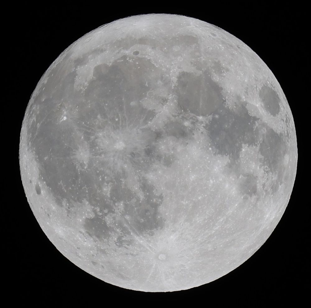 A monochrome photograph of a bright, full moon, specifically last night's full moon, the last full moon of August, aka, The Sturgeon Full Moon. Many craters and maria (mares) are clearly visible. The background is a deep black.
