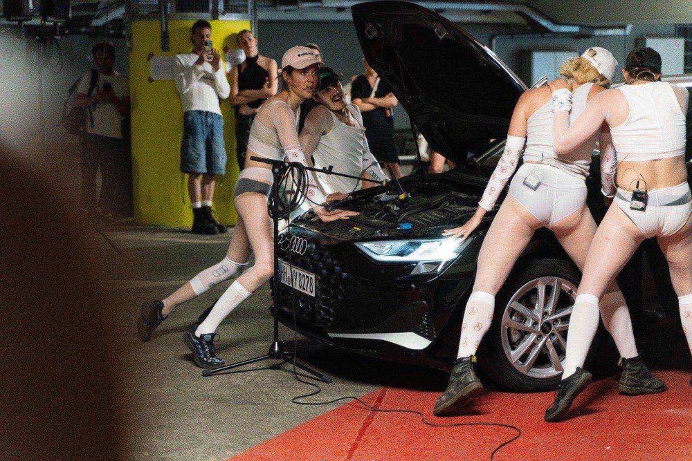 eine Gruppe von Menschen steht neben einem Auto