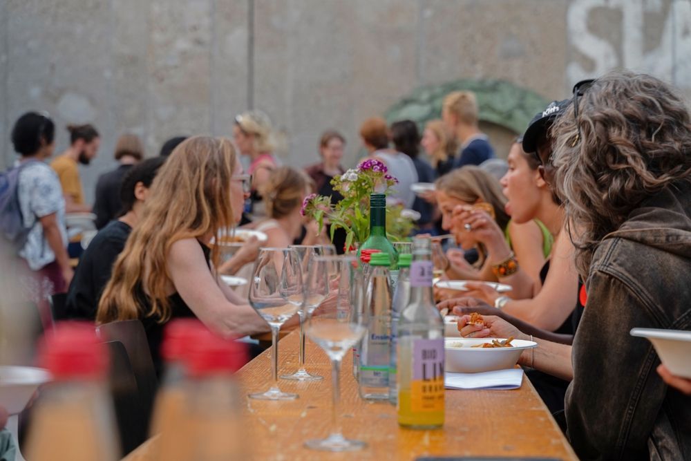 eine Gruppe von Menschen sitzt an einem Tisch mit Essen und Getränken