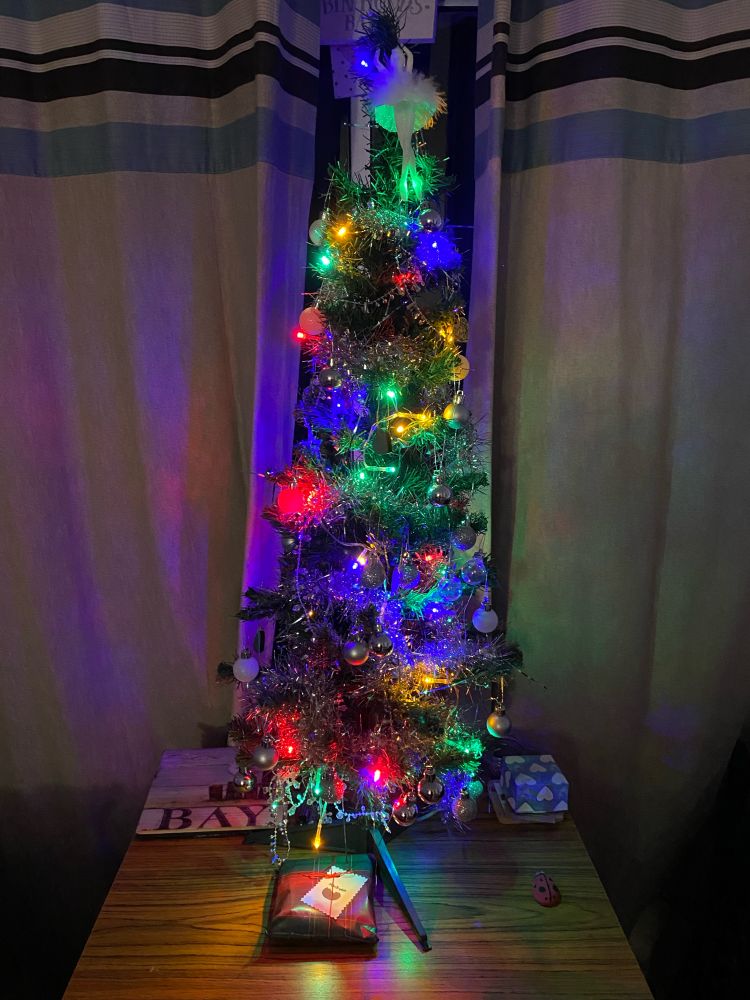 Small table top Christmas tree with coloured lights and ballerina on top