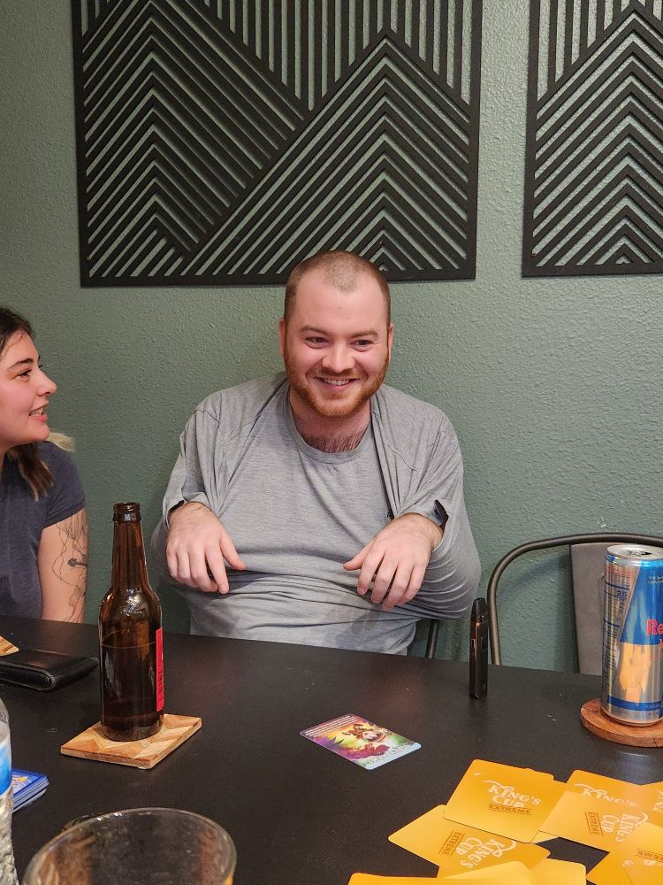 A man with his hands in his shirt like a T-rex.