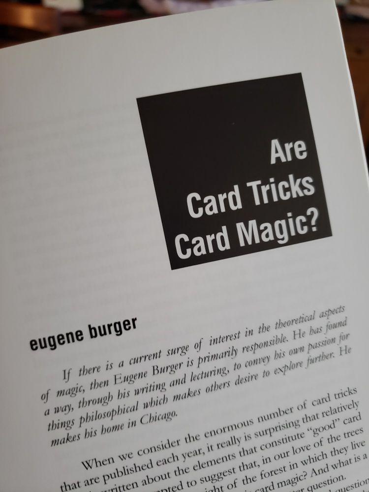 A photo of the relevant page in the book. The title "Are Card Tricks Magic" is superimposed in white font over a black square. Underneath, the authors name: "Eugene Burger", followed by a short biography in italic font, followed by the first paragraph of the essay. The text is cut off by the framing of the photo. 