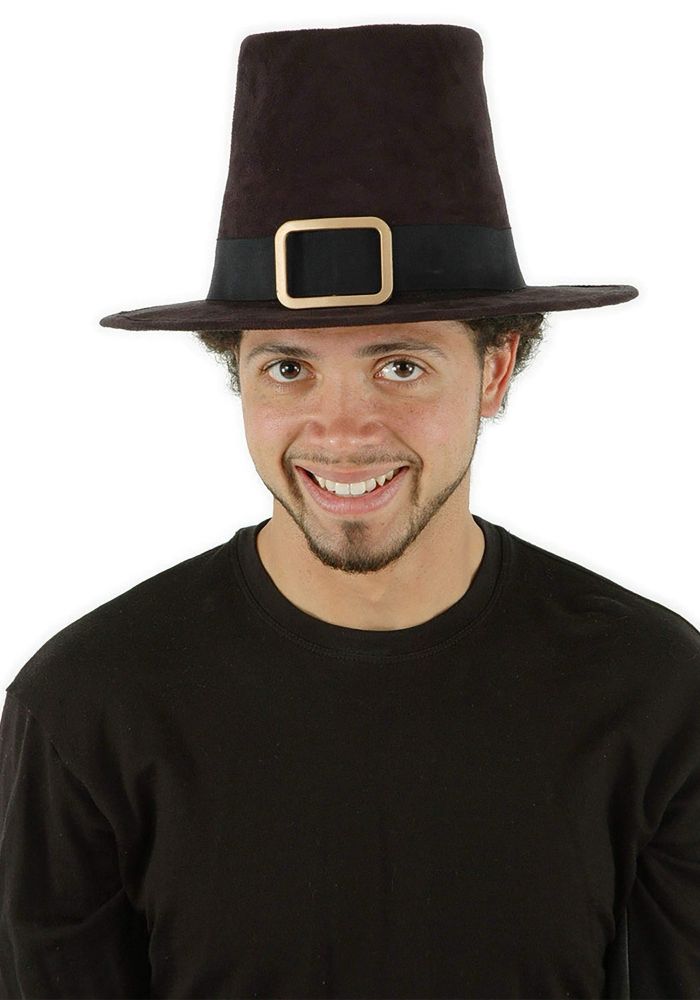 Man in a black t-shirt with 2000s style facial hair smiling and wearing a pilgrim hat with a buckle on it 