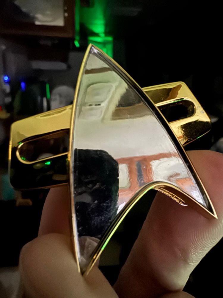 A Starfleet Communicator badge from the DS9  era through the VOY era.