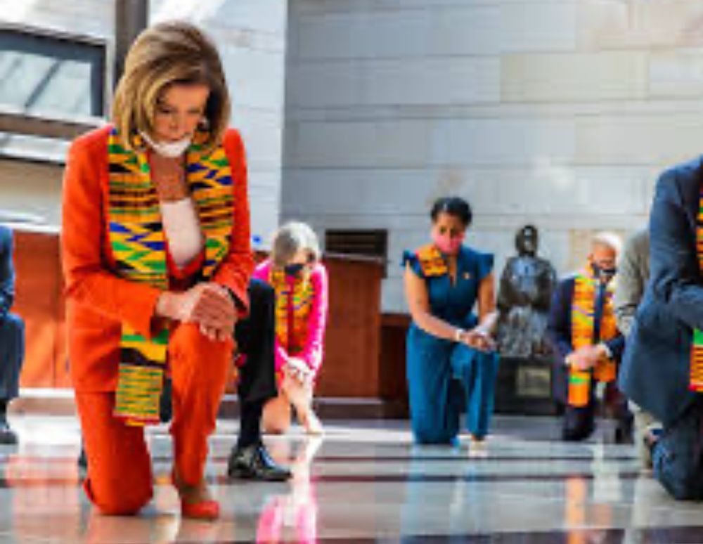 Democrats in Congress kneeling and wearing kinte cloth sashes