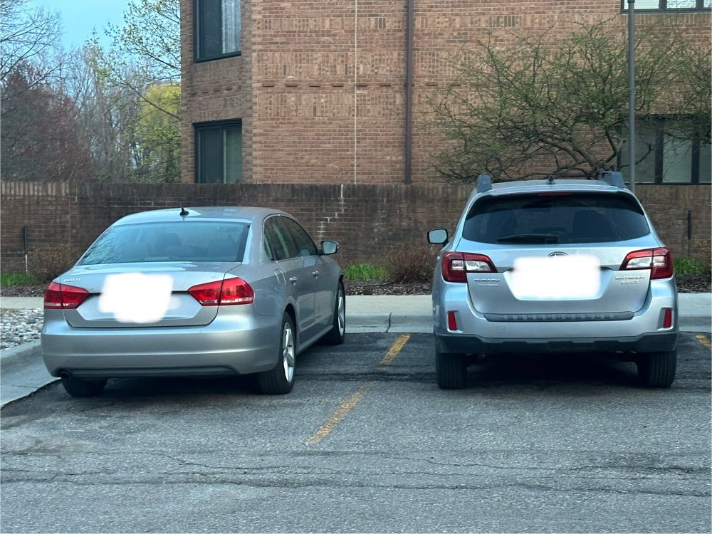Two silver cars parked side by side