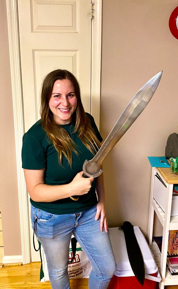 Angel D'Oliviera (first PhD student to graduate from the lab!) holding her PhD sword!