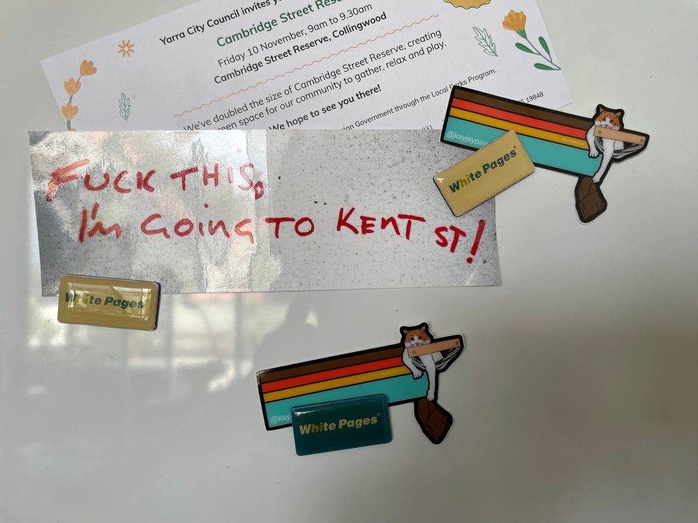 Photo from 2023 of a sticker that is still on our fridge that reads “Fuck this, I’m going to Kent St!” Stuck there with some very yellowed old White Pages magnets, which also pin some wonderful @kayjaypayyy cat stickers and a council notice about a street party. Being a rainy Melbourne Sunday morning, I am still in bed & too lazy to go take a fresh pic.