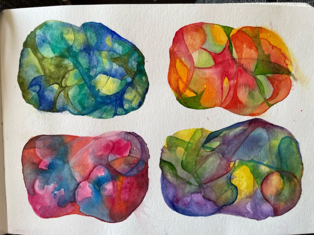 Photo of some watercolour blobs painted in a sketchbook, 2 rows of 2. Each blob is a combination of a few different colours, which move and swirl and connect in different ways within the amorphous shapes.