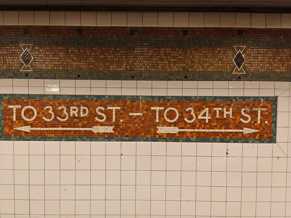 a mosaic sign in the New York subway saying "TO 33RD ST — TO 34TH ST"