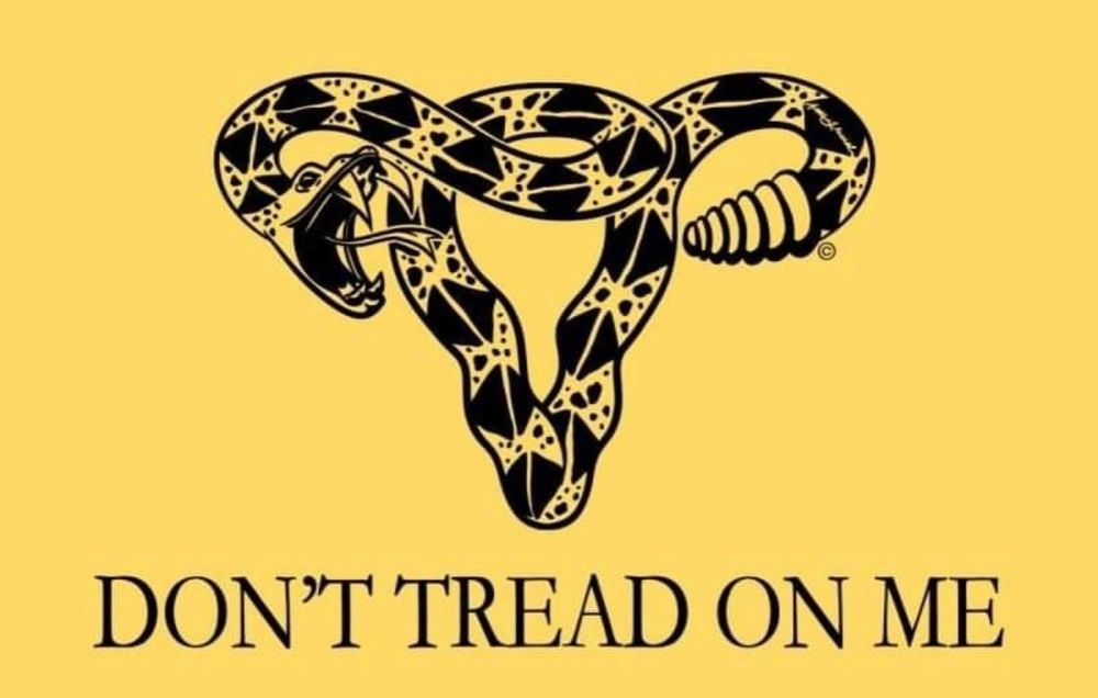 Yellow flag depicting a Rattlesnake in the shape of a uterus above the text "don't tread on me"