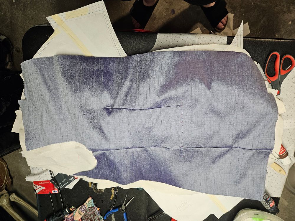 A silver violet fabric piece under construction.